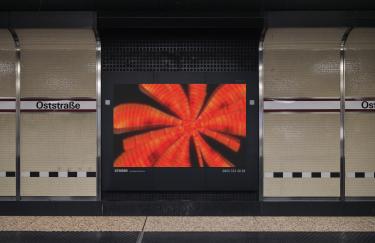 A platform at the Ostraße subway station in Düsseldorf where an advertising screen displays a video work by Yoora Park.