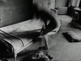 Hooykaas/Stansfield, Daydreams, 1972 Black-and white image of a blurry figure changing in front of a one-person bed. Film still from Hooykaas/Stansfield, Daydreams, 1972.