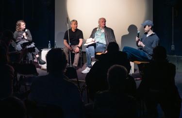 Auf der Bühne der Filmwerkstatt sitzen Linnea Semmerling, Juan Ruiz, Siegfried Saerberg und Dirk Sorge in einem Halbkreis dem Publikum zugewandt.